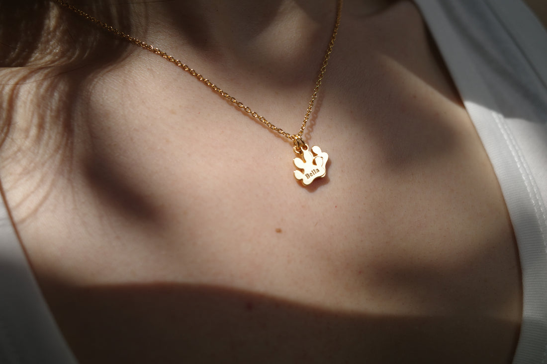 Gold paw necklace engraved with the name Bella